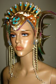 Ocean Queen Headdress, was made in strong but very light weight foam, decorate with gold paint, glitter, natural and handmade shells, rhinestones, pearls, metallic trims, natural turquoise beads and a natural turquoise and cooper front stone. The headpiece is lined with felt and have adjustable elastic on the back. Any question let me know. Thank you Whimsical Tall Crown Headpiece For Carnival, Carnival Crown Headpiece For Mardi Gras, Carnival Costume Party Headpiece With Round Crown, Carnival Round Crown Headpieces For Costume Party, Whimsical Crown Costume Hat For Carnival, Round Crown Headpiece For Carnival Costume Party, Crown Headpiece For Mardi Gras Carnival, Mardi Gras Carnival Crown Headpiece, Carnival Costume Headpiece With Round Crown