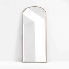 a mirror that is sitting on top of a shelf in front of a white wall