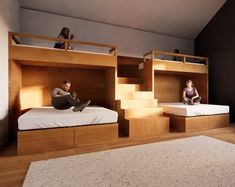 two people sitting on top of bunk beds in a room with wooden floors and stairs