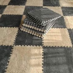 a black and white checkered rug on the floor with two pieces of fabric folded over it