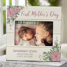 a mother's day frame with a baby and flowers on the front, sitting on a table