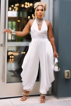 Step into the spotlight with our Ivory Serenity Jumpsuit. This exquisite piece combines the sophistication of a gown with the comfort and versatility of a jumpsuit. Perfect for weddings, gala events, or any occasion where you want to make a refined statement. Non-stretch jumpsuit Sleeveless/Halter Zipper closure 100% polyester Hand wash cold Inseam is 30 inches Model is wearing a small