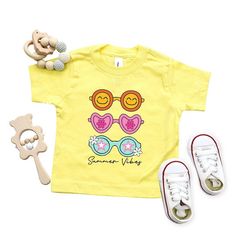 Looking for a cute tee for your kids? We have the perfect Sunnies Summer Vibes graphic tee addition to their closet! Also available in youth tees. Trendy Spring Playtime T-shirt, Cute Yellow T-shirt For Playtime, Fun Graphic Print T-shirt For Playwear, Summer Playtime Tops With Letter Print, Funny Print T-shirt For Spring Playtime, Funny Print Tops For Spring Playtime, Playful Funny Print T-shirt For Playtime, Playful T-shirt With Funny Print For Playtime, Cute T-shirt For Spring Playwear