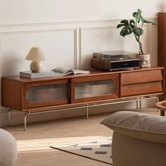 a living room with a couch, table and bookshelf next to a plant