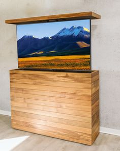 a flat screen tv sitting on top of a wooden stand in front of a wall