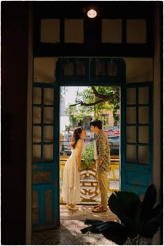 a man and woman standing in an open door to a building with the words love written on it