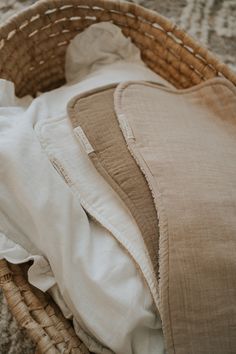 a wicker basket filled with clothes on top of a carpeted floor next to a rug