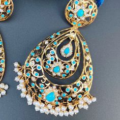 Design inspired from the Edwardian Era, these handcrafted jadau earrings have been made in sterling silver with 22K gold plating and embellished with freshwater pearls and turquoises. The earrings have a clip at the back and a threaded screw. Weight : 50 GMs, Height : 10 cm, Width : 5.5 cm Elegant Turquoise Kundan Earrings, Turquoise Kundan Earrings For Festivals, Turquoise Kundan Chandbali Earrings, Festive Kundan Turquoise Earrings, Turquoise Kundan Earrings For Wedding, Festive Turquoise Kundan Earrings, Traditional Turquoise Drop Earrings, Turquoise Jewelry With Matching Earrings For Festivals, Elegant Turquoise Earrings For Festivals