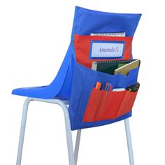 a blue and red chair with a pocket on it's back filled with books