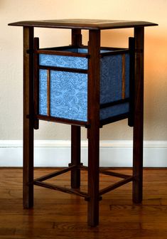 a wooden table with a blue drawer on it's side and a white wall in the background