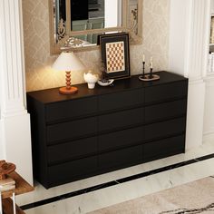 a black dresser with a lamp on top and a mirror in the corner next to it