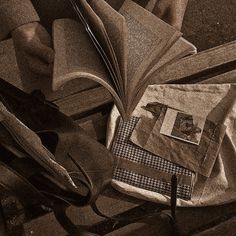 an open book sitting on top of a wooden table next to scissors and other items