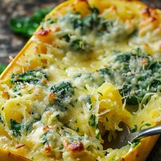 a yellow dish filled with pasta and spinach