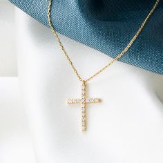 Experience the harmonious blend of tradition and elegance with our 14K Solid Gold Cross Necklace. This finely handcrafted piece features a petite cross pendant, measuring 7 mm wide and 11 mm tall, adorned with a singular cubic zirconia gemstone that captures the light and signifies purity. The skinny cable chain, available in lengths from 14 to 20 inches, provides a customizable fit for diverse preferences and comfort. Key Features: Refined Symbolism: Delicate cross pendant design for a modest e