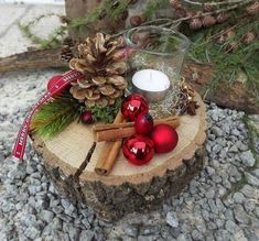 a candle and some christmas decorations on a tree stump