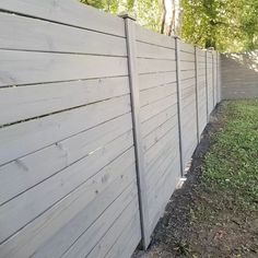 a wooden fence is next to the grass