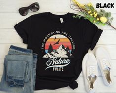 "This Nature Awaits TShirt is perfect for any adventure lover! Makes a great shirt for camping, hiking, vacationing, and enjoying the outdoors! **DETAILS** This Bella Canvas 3001 unisex t-shirt is soft and lightweight, the comfiest shirt you will own! It's comfortable and flattering for both men and women. - Unisex sizing please refer to sizing chart in listing photos - 100% combed and ring-spun cotton  - Medium fabric weight **PRINTING** - DTG (Direct To Garment) Printed  **CARE** - Machine wash: cold - Hang to dry preferred. Tumble dry low - Do not iron directly on print **SHIPPING** - Products are shipped after 2-7 days in production **POLICIES** All items are made when you place your order. For this reason we are unable to accept returns / exchanges unless there's a defect in the item Black T-shirt For Hiking With Letter Print, Black Hiking T-shirt With Letter Print, Black Letter Print T-shirt For Hiking, Casual Black T-shirt For Hiking, Camping Clothes, Hiking Tshirt, Mountain Tshirt, Camping Outfits, Comfy Shirts