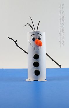 a toilet paper roll with a frozen snowman face on it and some twigs sticking out of it