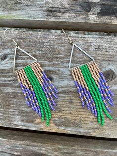 Gold, purple, and green czech seed beads have been hand woven onto a stainless steel triangle to create a long fringe that moves with you. Perfect for your Mardi Gras outfit! Each bead has been touched by my hand multiple times, a lot of time and energy goes into each piece. Please note that color/tone may differ in person due to monitor brightness and other settings. Adjustable Triangle Beaded Earrings, Adjustable Triangle Beaded Jewelry, Adjustable Triangular Beaded Jewelry, Bohemian Triangle Beaded Earrings, Fringe Beaded Earrings, Mardi Gras Outfits, Long Fringe, Purple And Green, Tampa Fl