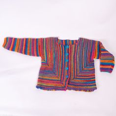 a multicolored knitted sweater is laying on a white surface, with one button down the middle