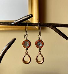 Details & measurements: ~ Beautiful Czech glass flower beads in red-orange opaline with an earthy Picasso finish (12mm) ~ Accented by antique brass teardrop dangle charms with a patina finish (17 x 11mm) and tiny dark olive green spacer beads ~ Earrings hang from antique brass ear wires ~ They hang just over 2" long ♡ Packaged safely & sustainably in a kraft box with cotton ribbon & dried organic florals. This makes for a beautiful gift, or something pretty for yourself! All packaging materials are zero waste and also reusable. ♡ As well, we always ship with plastic-free packing materials. Sustainability is an integral part of our lives, and we aim to bring that same dedication to our small business. Bohemian Brown Dangle Flower Earrings, Adjustable Bohemian Drop Flower Earrings, Vintage Red Teardrop Jewelry, Unique Handmade Adjustable Teardrop Earrings, Brown Bohemian Drop Flower Earrings, Unique Red Flower Earrings, Orange Adjustable Dangle Flower Earrings, Artisan Red Teardrop Earrings, Red Drop Earrings With Flower Charm