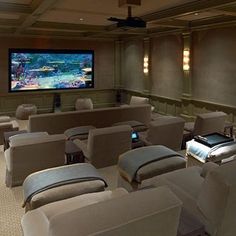 a large room with couches, chairs and a flat screen tv on the wall