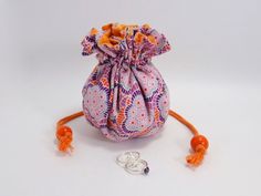 a small bag with orange handles and beads