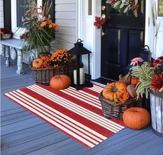 pumpkins and gourds are sitting on the front porch for fall decorating