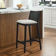 a white counter top sitting next to a wooden bar with a stool in front of it