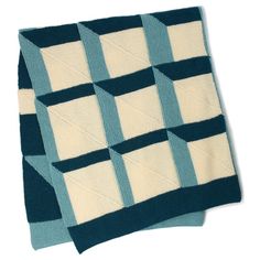 two blue and white knitted squares sitting on top of each other