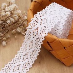 a white lace on a basket next to flowers