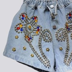 Uncover the perfect balance of classic vibe and modern charm with our 2023 Summer Collection's flower ornament embellished denim shorts. With a high-waist. free silhouette. these y2k inspired shorts are accented with buttons and rubber closure for a secure fit. Make a statement in these versatile shorts and step into the season with timeless style and effortless grace!Distinctive Features: Y2K-Style: An ode to the past. fashionably reimagined with a modern twist. High-Waist: Captivatingly cinche Y2k Style Jean Shorts For Summer, Y2k Jean Shorts For Summer, Summer Y2k Jean Shorts, Y2k Style Short Jean Shorts For Summer, Y2k High-waisted Shorts, Spring Denim Blue Bottoms With Rhinestones, Y2k Style Denim Blue Jean Shorts For Summer, Y2k Denim Blue Jean Shorts For Summer, Spring Denim Blue Rhinestones Bottoms