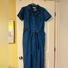 Brand New, Tags And Extra Button Still Attached. Blue Jean Jumpsuit With Button Up Front And Waist Tie Belt (5 Belt Loops To Hold Securely). Short Sleeves And 6 Pockets, Two On Front Hip, Two On Front Breast, Two (Still Sewn Shut) On Butt. Wide Leg Relaxed Fit. Spring Collared Denim Jumpsuits And Rompers, Collared Denim Jumpsuit With Button Closure, Collared Blue Jumpsuits And Rompers For Spring, Blue Collared Jumpsuits And Rompers For Spring, Fitted Collared Denim Jumpsuit For Summer, Blue Denim Workwear Jumpsuit With Short Sleeves, Fitted Blue Jumpsuits And Rompers With Button Closure, Blue Denim Jumpsuit With Buttons For Spring, Blue Short Sleeve Denim Jumpsuit For Work