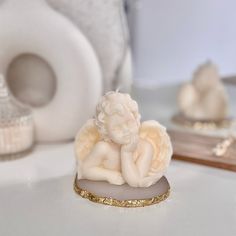 an angel figurine sitting on top of a white table next to other items