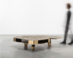 a person standing in front of a table that is shaped like an upside down coffee table