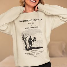 Introducing the must-have piece for all bookworms, literature lovers, and Emily Bronte fans - the Wuthering Heights sweatshirt! This unique and stylish sweatshirt features the first page of Chapter 1 on the back. If you are a Wuthering Heights lover or simply appreciate classic literature, this sweatshirt is a must-have addition to your wardrobe. Featuring a one-of-a-kind design, this Wuthering Heights sweatshirt showcases a special touch with the first chapter printed on the back. It's the perf Relaxed Fit Crew Neck Bookish Sweatshirt, Literary Long Sleeve Cotton Tops, Literary Long Sleeve Tops With Letter Print, Bookworm Gifts, Literary Shirts, Emily Brontë, Emily Bronte, Wuthering Heights, Literary Gifts