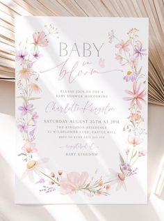 a baby shower is shown with pink flowers and greenery