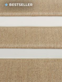 carpeted stairs with white handrails and beige carpeting on the bottom step