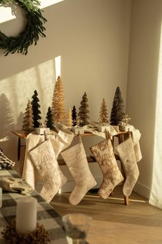 stockings hung on a table with christmas trees in the background