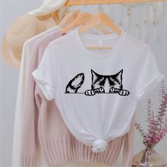 As a Serenad Craft proudly announce our new t -shirts. These are best quality t - shirts and designs. Cat Shirt, Cat Face Shirt, Gift for Cat Lover, Cat Mom Shirt, Cat Shirts for Women, Cat Owner Gift Idea, Cute Cat Shirt, Kitty Shirt&SIZE• Please check size chart before order• Our t-shirts are unisex• If ladies more fit, please order one size down.&CARET-shirts are made of 100% combed ring spun cotton and 4.2 oz.Just wash inside out warm and no iron on decoration. Do not bleach do not d White Short Sleeve Shirt With Cat Print, White Crew Neck Shirt With Cat Print, White Crew Neck Top With Cat Design, White Casual Shirt With Cat Print, White Cotton Shirt With Cat Design, Feyonce Shirt, Cat Shirts For Women, Cat Tee Shirts, Nyc Shirt