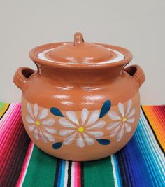 a clay pot with flowers painted on it