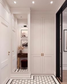 a hallway with black and white tile flooring and doors leading to a dressing room