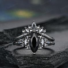 a black diamond ring sitting on top of a rock