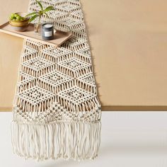 the table runner is made from macrame yarn and has a potted plant on it