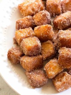 some sugared doughnuts are on a white plate