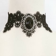 A black or purple faceted cabochon gem in a silver metal oval frame made of corrosion and tarnish resistant zinc alloy which is also a removable brooch!   Oval frame measures 4 x 3.5 cm (approx)  Gem is  2.5 x 1.8 cm (approx) Circumference is adjustable from 30 to 35 cm (approx) Width of choker is 5.5cm at widest point. Black Vampire Jewelry For Halloween, Vampire Style Black Jewelry For Halloween, Oval Cabochon Jewelry For Party, Gothic Metal Jewelry For Party, Gothic Black Oval Jewelry, Black Oval Gothic Jewelry, Adjustable Vampire Jewelry For Halloween, Gothic Costume Jewelry Choker, Silver Vampire Style Metal Jewelry