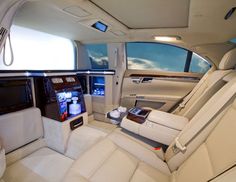 the interior of a luxury car with all white leather seats and electronic entertainment system in center console