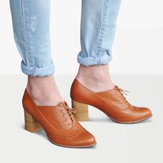 These oxford booties feature a rich sunny brown tone complemented by a matching beige sole and sturdy block heel, providing both durability and sophistication. The intricate brogue details add a touch of elegance and texture, elevating the overall design. Crafted with meticulous attention to detail, these booties offer a perfect balance of style and comfort, making them ideal for any occasion.  Upper & lining: genuine leather Closure: lace-up Fit: true to size  Width: available in regular (B)  S Brown High Heel Lace-up Shoes For Fall, Retro Brown Lace-up Shoes With Round Toe, Brown Almond Toe Oxfords With Rubber Heel Cap, Brown Almond Toe Lace-up Shoes With Rubber Heel Cap, Brown Oxfords With Almond Toe And Rubber Heel Cap, Brown Brogue Heels For Work, Vintage Brown Oxfords For Spring, Brown High Heel Oxfords With Brogue Detailing, Retro Brown Lace-up Oxfords