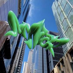 a green sculpture in the middle of a city