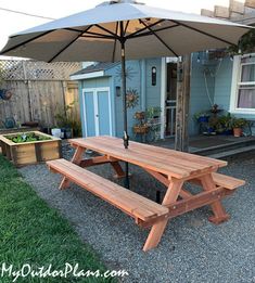 a wooden picnic table with an umbrella over it